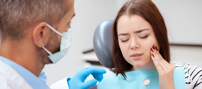 Woman with toothache visiting emergency dentist in Tappan, NY