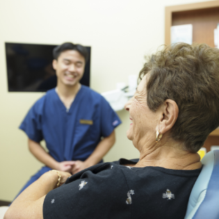 Team member smiling and checking in dental patient