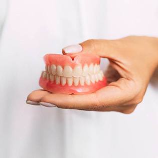 person holding dentures