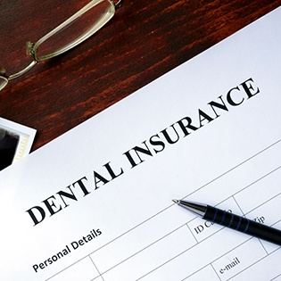 A dental insurance form on a wooden desk