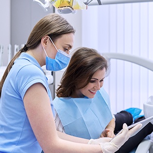 A woman paying the cost of her tooth extraction